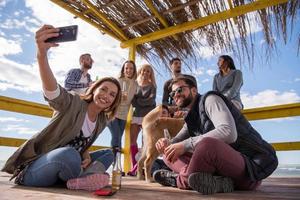 grupo de amigos divirtiéndose el día de otoño en la playa foto