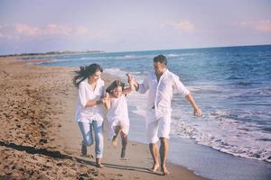 familia joven feliz divertirse en la playa foto