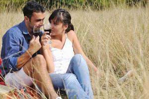 happy couple enjoying countryside picnic in long grass photo