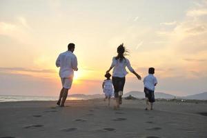 happy young family have fun on beach at sunset photo