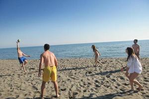 grupo de jóvenes divertirse y jugar voleibol de playa foto