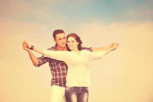 feliz pareja joven divertirse en la playa foto