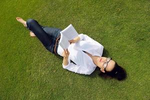Young woman reading a book in the park photo
