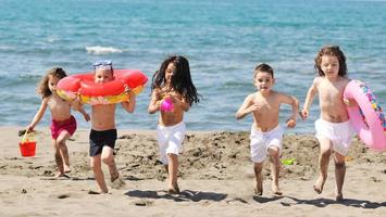 grupo infantil divertirse y jugar con juguetes de playa foto