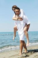 happy young couple have fun on beach photo