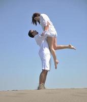 happy young couple have fun on beach photo