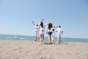 grupo de gente feliz divertirse y correr en la playa foto