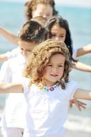 Grupo de niños felices jugando en la playa foto