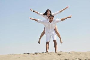 happy young couple have fun on beach photo