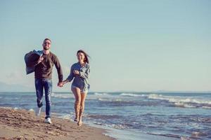 Loving young couple on a beach at autumn sunny day photo