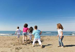 happy child group playing  on beach photo