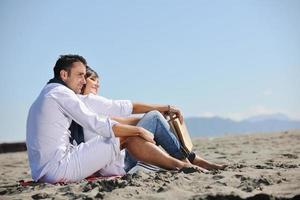 pareja joven disfrutando de un picnic en la playa foto