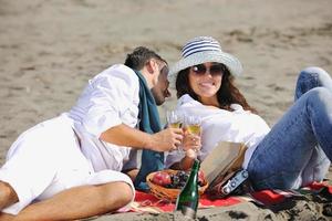 young couple enjoying  picnic on the beach photo