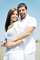 feliz pareja joven divertirse en la playa foto