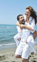 happy young couple have fun on beach photo