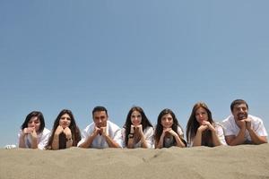 grupo de jóvenes felices divirtiéndose en la playa foto