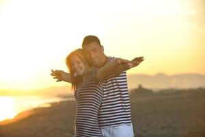 feliz pareja joven divertirse en la playa foto