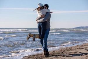 Loving young couple on a beach at autumn sunny day photo