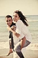 feliz pareja joven divertirse en la hermosa playa foto