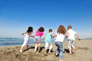 grupo de jóvenes felices divertirse en la playa foto