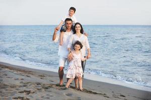 familia joven feliz divertirse en la playa foto