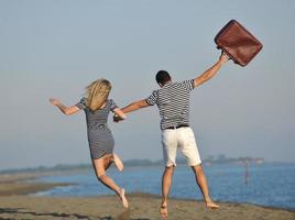 couple on beach with travel bag photo