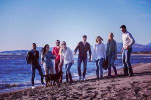 young friends jumping together at autumn beach photo