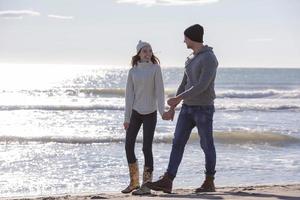 Loving young couple on a beach at autumn sunny day photo