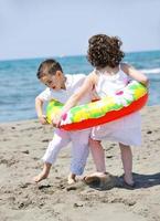 Grupo de niños felices jugando en la playa foto