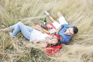 happy couple enjoying countryside picnic in long grass photo