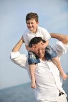 feliz padre e hijo se divierten y disfrutan del tiempo en la playa foto