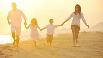 happy young family have fun on beach at sunset photo