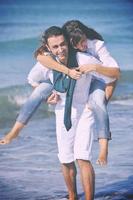 feliz pareja joven divertirse en la hermosa playa foto