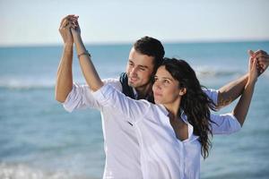 feliz pareja joven divertirse en la hermosa playa foto