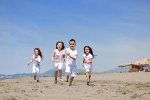 happy child group playing  on beach photo