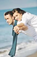 feliz pareja joven divertirse en la hermosa playa foto