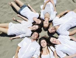 grupo de jóvenes felices divirtiéndose en la playa foto