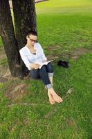 Young woman reading a book in the park photo