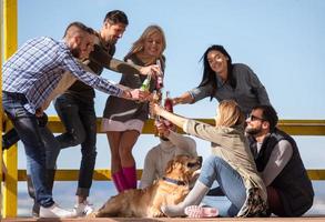 grupo de amigos divirtiéndose el día de otoño en la playa foto