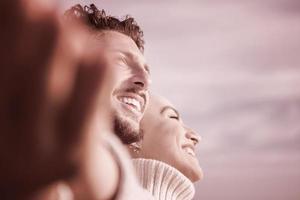 Loving young couple on a beach at autumn sunny day photo