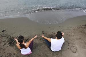 pareja yoga playa foto