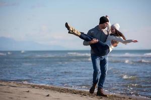 amorosa pareja joven en una playa en el día soleado de otoño foto