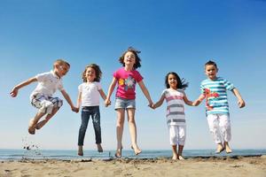 grupo de jóvenes felices divertirse en la playa foto