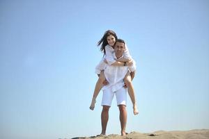 feliz pareja joven divertirse en la playa foto