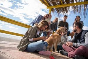 Group of friends having fun on autumn day at beach photo