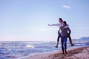 pareja divirtiéndose en la playa durante el otoño foto