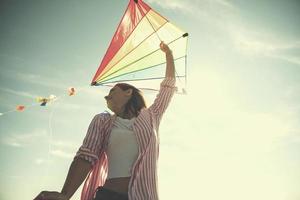 Young Woman with kite at beach on autumn day photo
