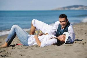 pareja joven disfrutando de un picnic en la playa foto