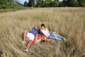 pareja feliz disfrutando de un picnic en el campo en hierba larga foto