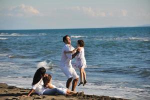 familia joven feliz divertirse en la playa foto